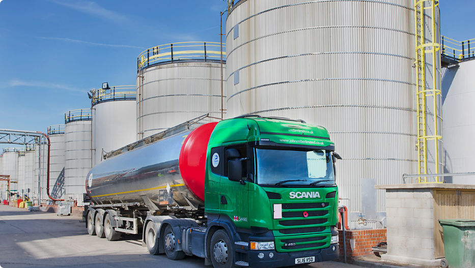 cargo lorry parked next to multiple industrial silos