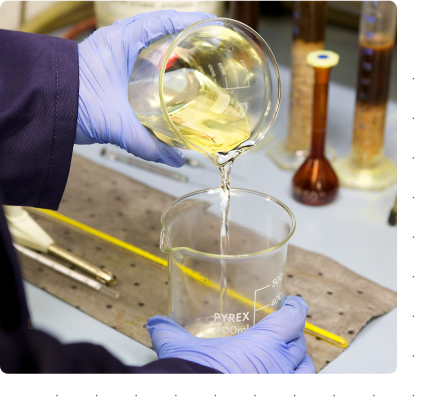 technician pouring biofuel from one beaker into another