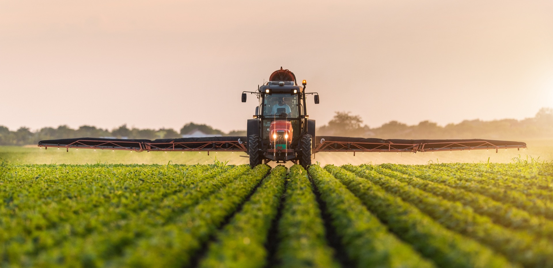 tractor spraying field with fertiliser
